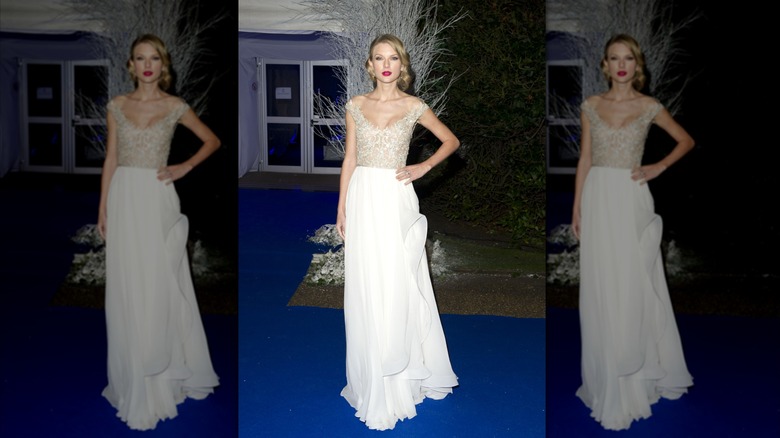 Taylor Swift on the red carpet in a white gown with a beaded bodice