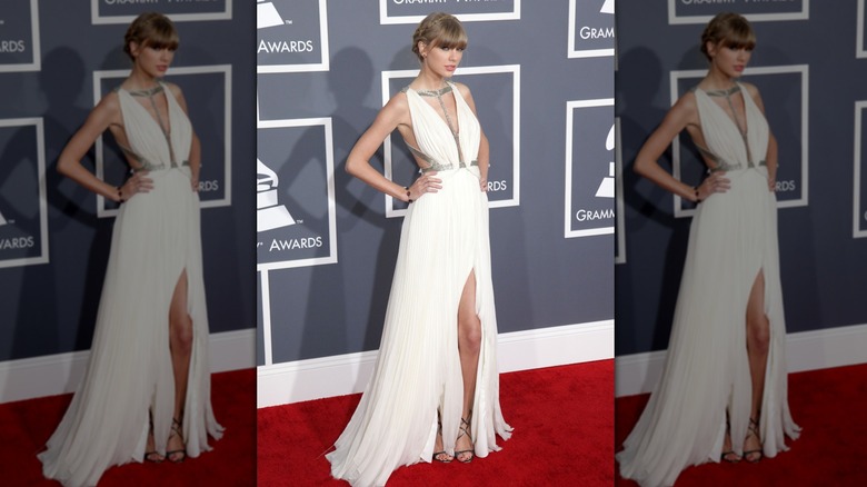 Taylor Swift on the red carpet in a white gown with silver straps