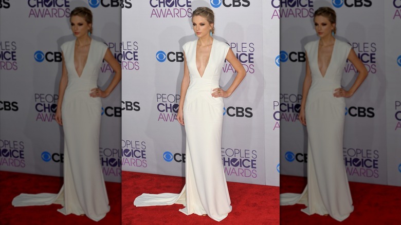 Taylor Swift on the red carpet in a sleek white gown