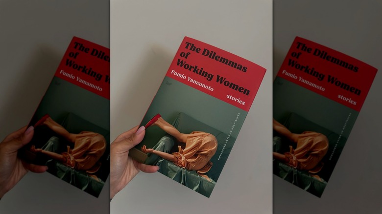 A person holding a copy of The Dilemmas of Working Women by Fumio Yamamoto