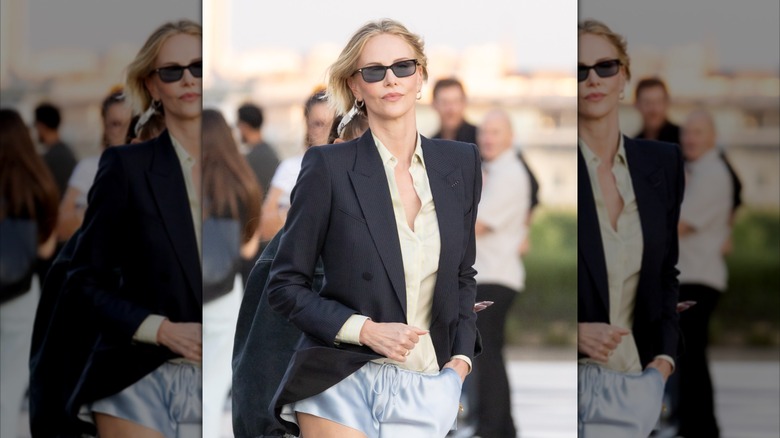 Charlize Theron wearing a black blazer and blue silk shorts