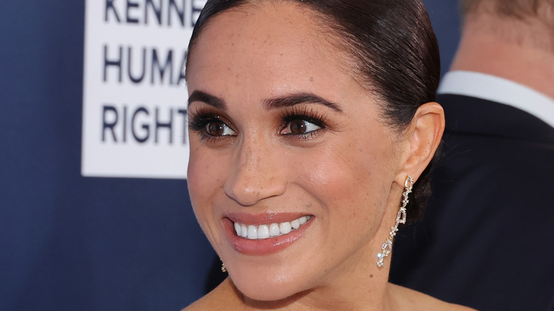 Meghan, Duchess of Sussex smiles at a red carpet event