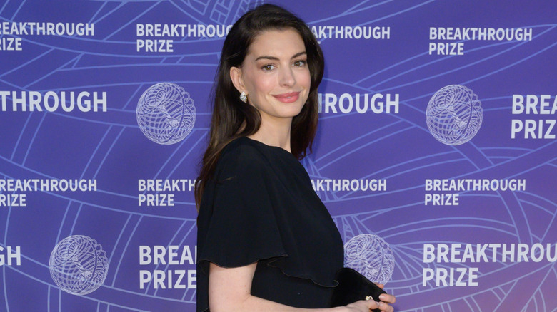 Anne Hathaway on the red carpet looking over her shoulder
