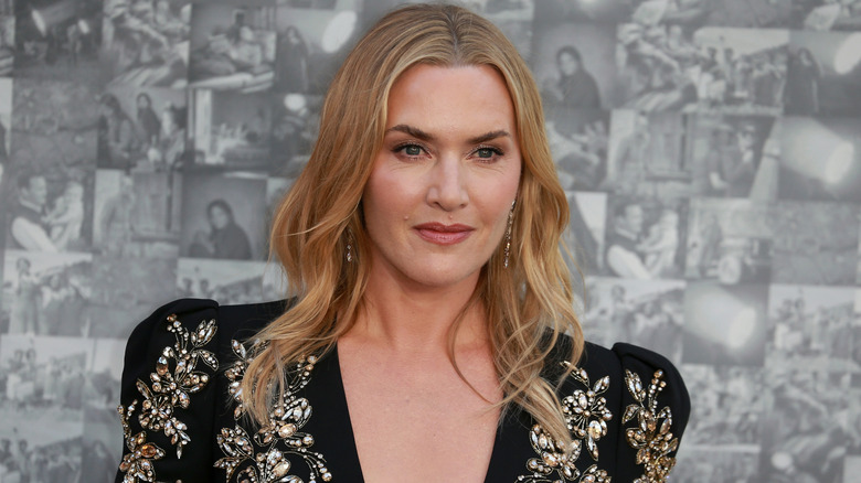 A close-up picture of Kate Winslet on the red carpet, wearing a beaded, black, V-neck top
