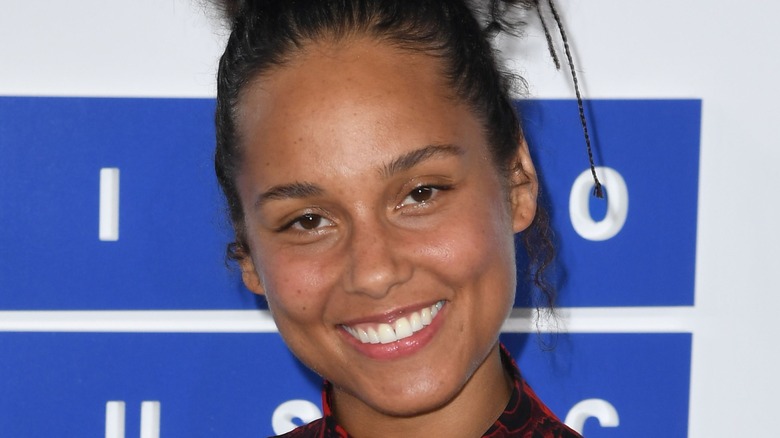 Alicia Keys smiling without makeup on the 2016 MTV VMAs red carpet.