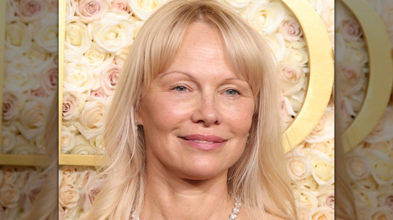 Pamela Anderson smiling without makeup on the red carpet at the 2025 Golden Globe Awards.