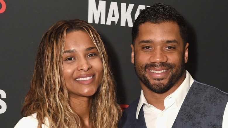 Ciara posing alongside Russell Wilson with no makeup on the red carpet at the 2017 Makers Conference Day event.