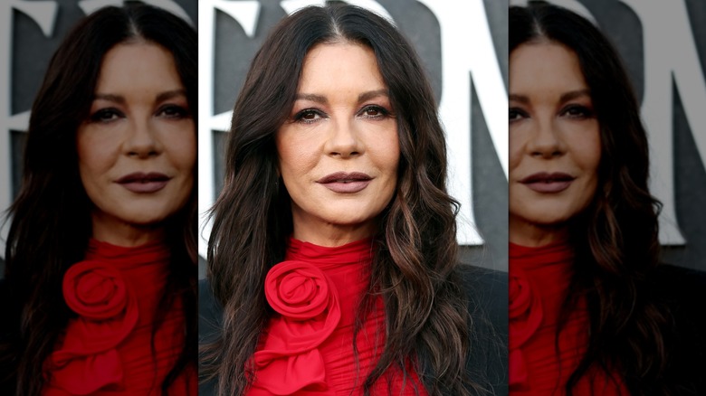 Close-up of Catherine Zeta-Jones wearing a dark lip color and middle-parted hairstyle at a "Wednesday" event