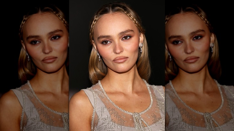 Close-up of Lily-Rose Depp posing at a 2024 premiere while wearing small braids on either side of her face