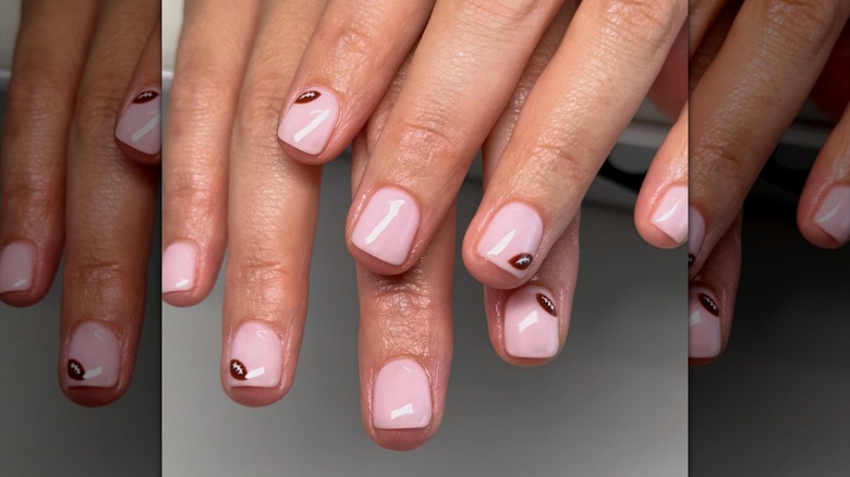 A close-up of a simple manicure with little footballs on some of the nails on Instagram