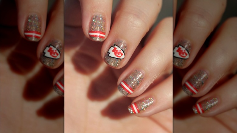 A close up of a short sparkly manicure for the Chiefs