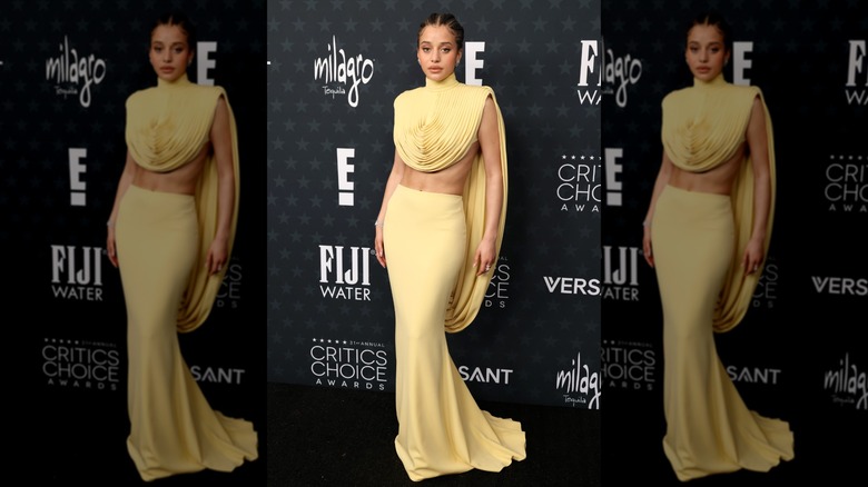 Chase Infiniti wearing a floor-length skirt and matching cropped top featuring a turtleneck and circular pattern