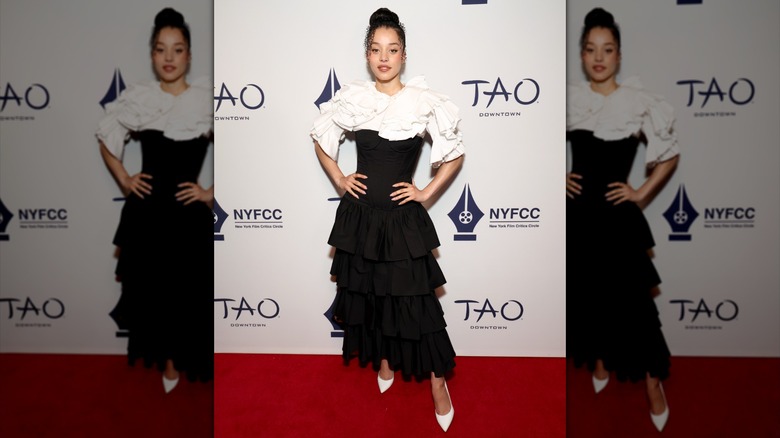Chase Infiniti posing with her hands on her hips while wearing a black-and-white dress