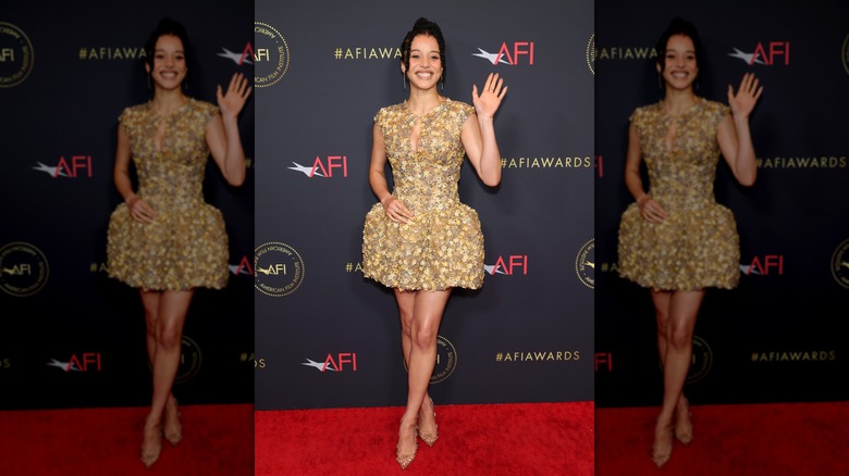 Chase Infiniti waving while wearing a mini-dress with a keyhole neckline and small, floral appliques