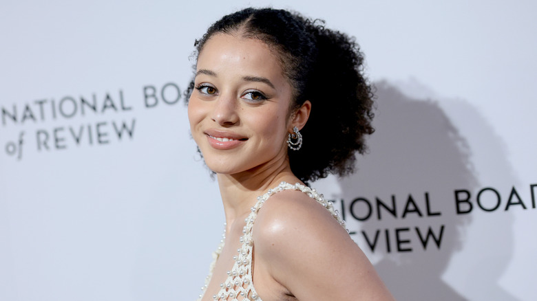 Chase Infiniti smiling over her shoulder while wearing a thick, curly ponytail