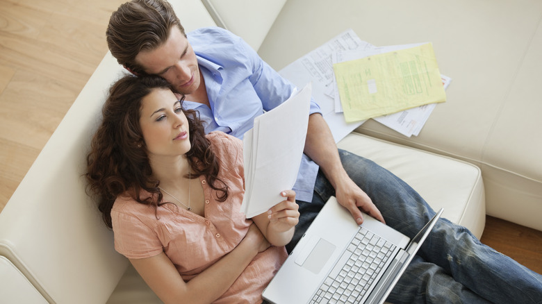 Couple examining finances on couch