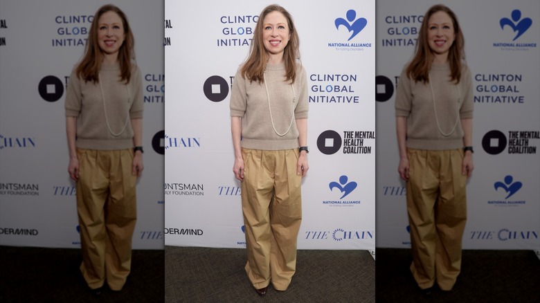 Chelsea Clinton smiling at an event with a beige sweater
