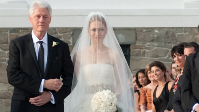 Bill Clinton walking Chelsea Clinton down the aisle as Ghislaine Maxwell looks on as a guest