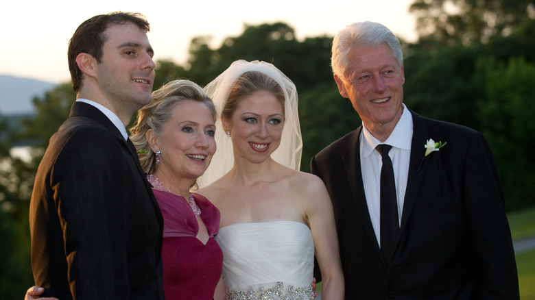 Chelsea Clinton posing for photos with her parents and her husband during her wedding