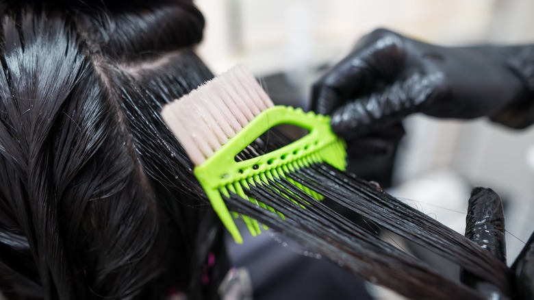 woman getting hair straightening treatment 