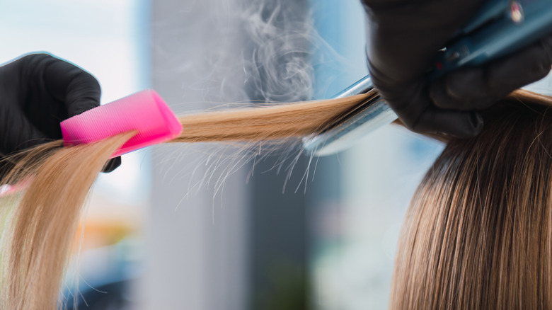 woman getting hair straightened 