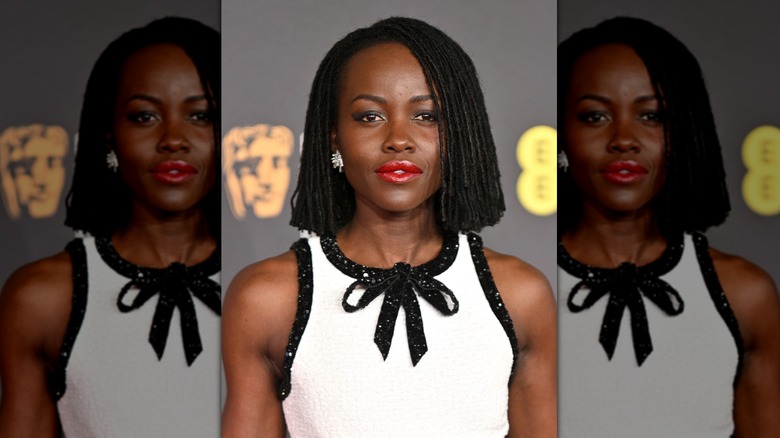 Lupita Nyong'o with chin-length twists and a red lip on the red carpet