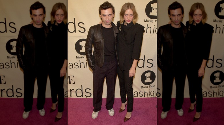 Chloë Sevigny posing with designer Nicolas Ghesquière while wearing an all-black suit