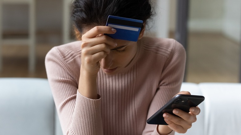 Woman cringes checking her debit account