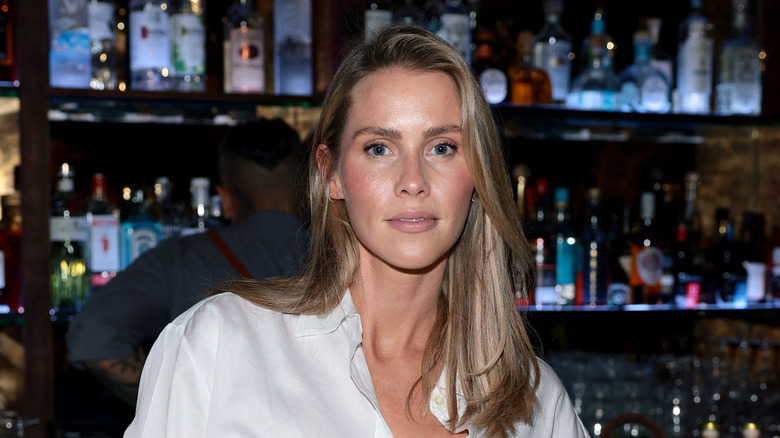 Claire Holt in a white button down blouse at an event