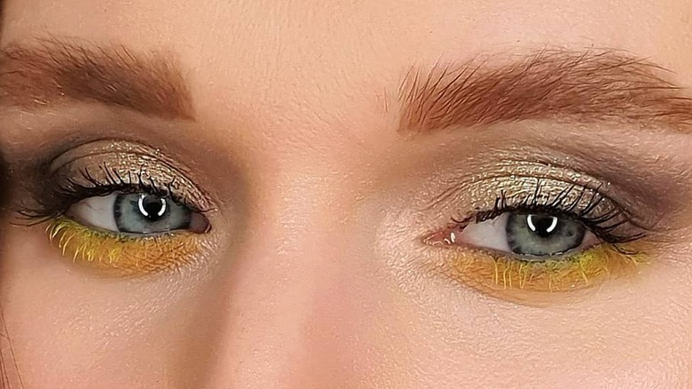 blue eyed woman wearing yellow mascara 