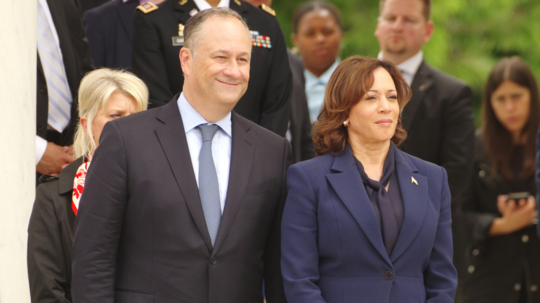 Doug Emhoff and Kamala Harris standing together in coats
