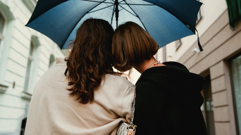 Queer couple sharing an umbrella 