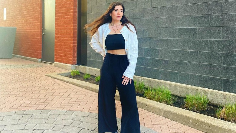 Woman posing in black pants and crop top 