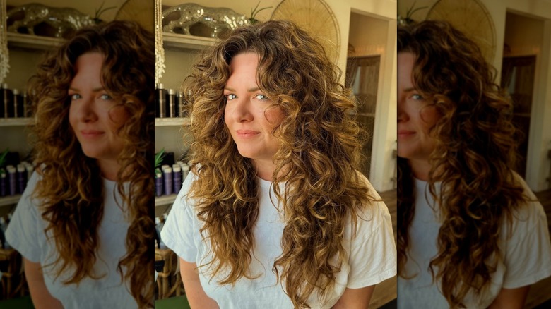 A woman with long curly hair with added layers