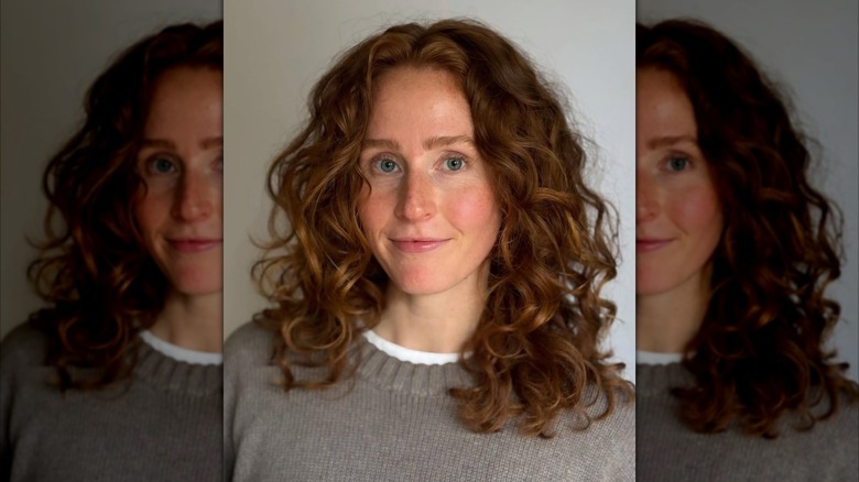 A woman with red hair cut into a shoulder-length style with face framing layers