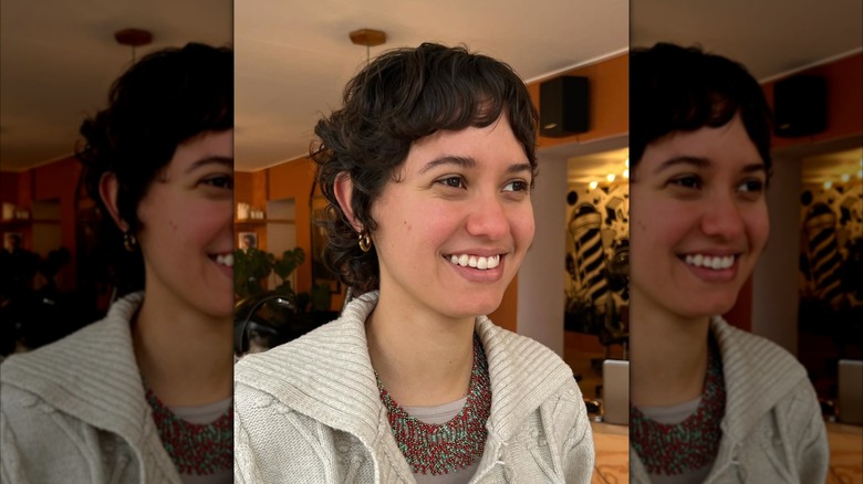 A woman with a curly pixie hair cut
