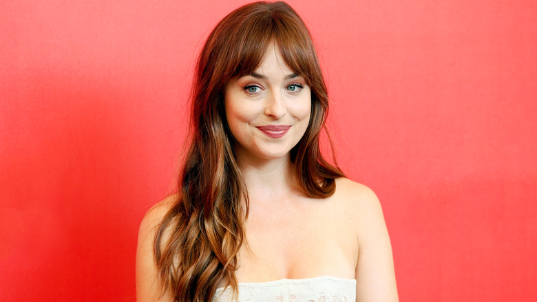 Dakota Johnson smiles on the red carpet in 2018