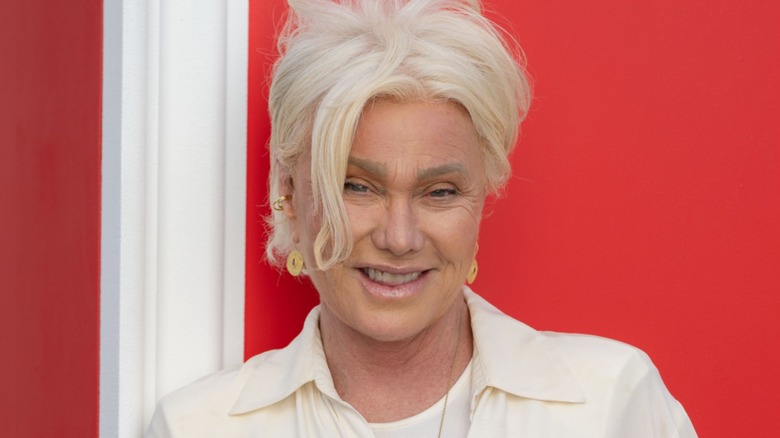 Deborra-Lee Furness smiling in front of a red background