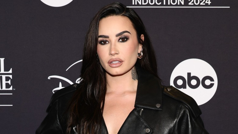 Demi Lovato posing on the red carpet with long hair extensions