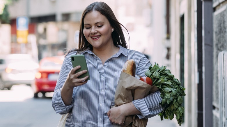 A woman carrying healthy groceries 
