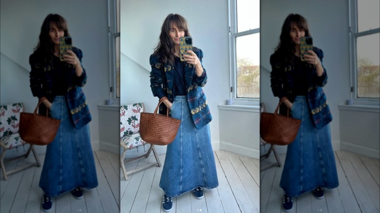 A mirror selfie of a woman wearing a denim maxi skirt and a patterned wool blazer