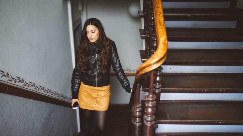 woman in stairwell wearing skirt and tights