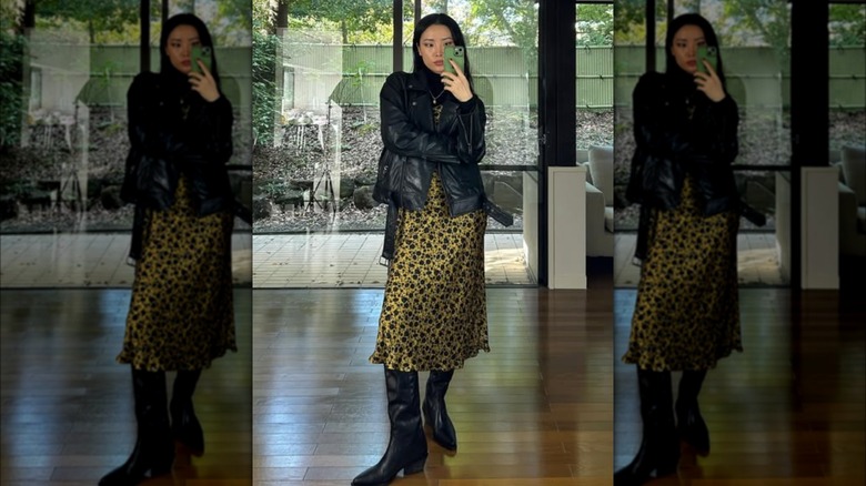 A mirror selfie of a woman wearing a silk slip dress and a leather motorcycle dress