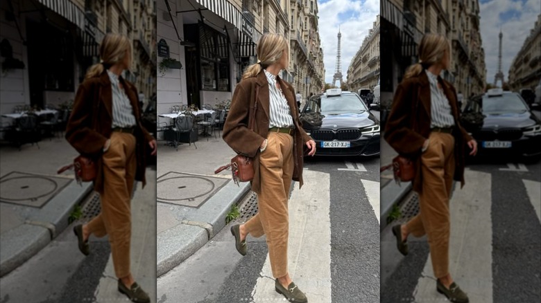 A woman crossing the street in tailored velvet pants with the Eiffel Tower in the background