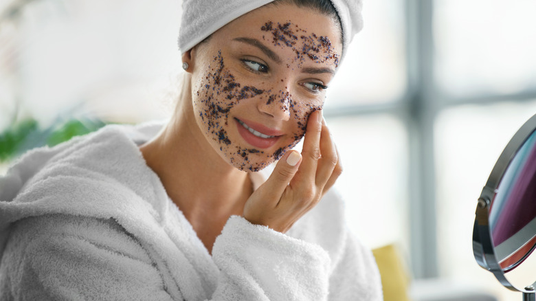 Woman applying face scrub