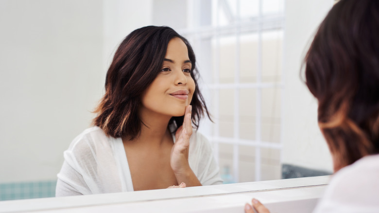 A woman assessing her face