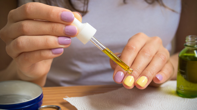 A woman applying cuticle oil