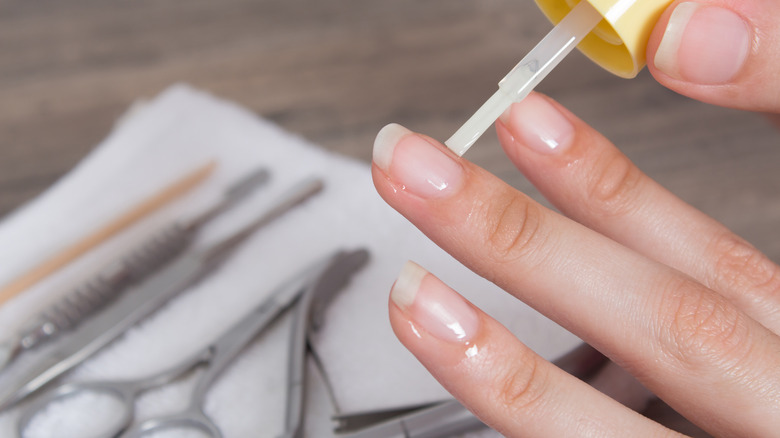 A woman applying cuticle oil