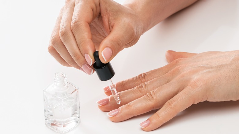 A woman applying cuticle oil