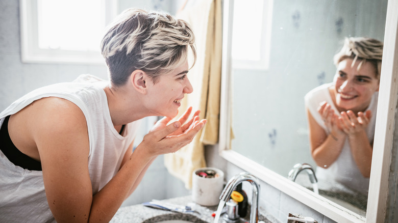 person washes face